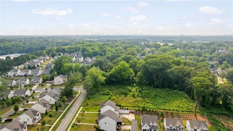 an aerial view of residential houses with outdoor space and trees