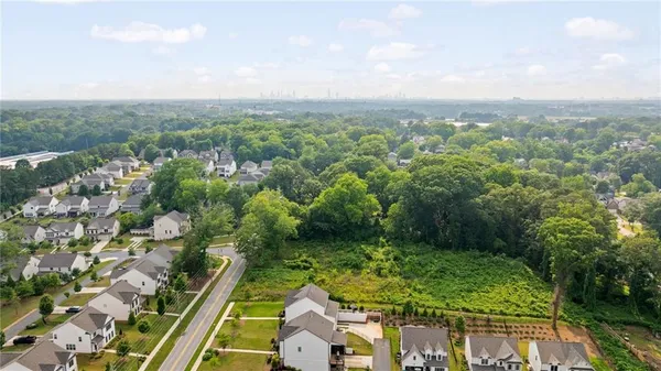 an aerial view of residential houses with outdoor space and trees