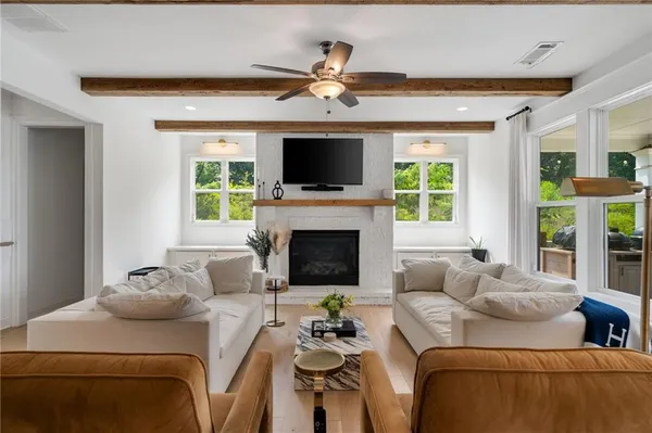 a living room with furniture a flat screen tv and a fireplace