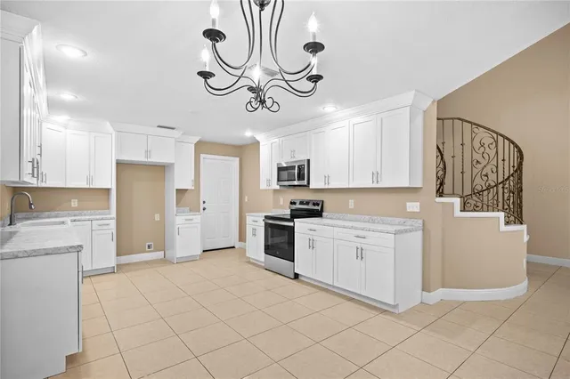 a kitchen with white cabinets and stainless steel appliances