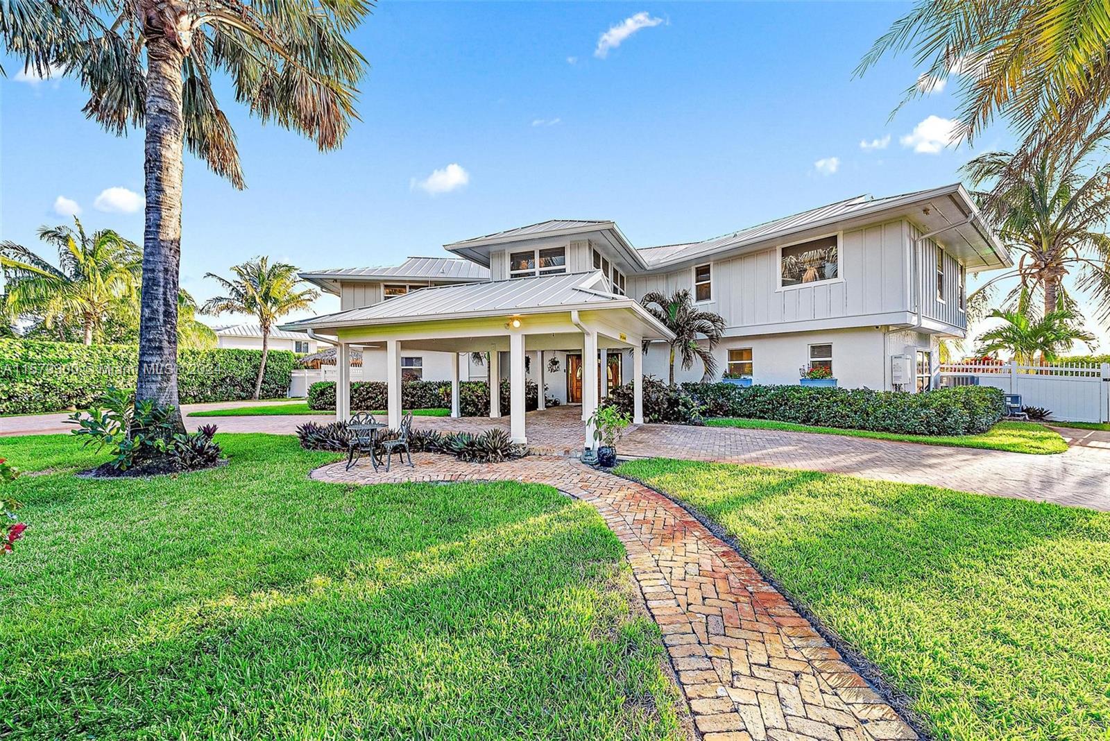 4643 Cheerio Way Stuart, FL 34997 - Photo 34 of 69 a front view of a house with swimming pool having outdoor seating