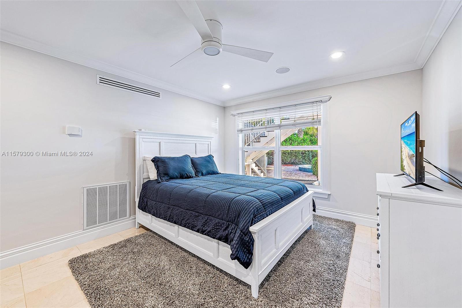 4643 Cheerio Way Stuart, FL 34997 - Photo 67 of 69 a bedroom with a bed and a dresser with rug