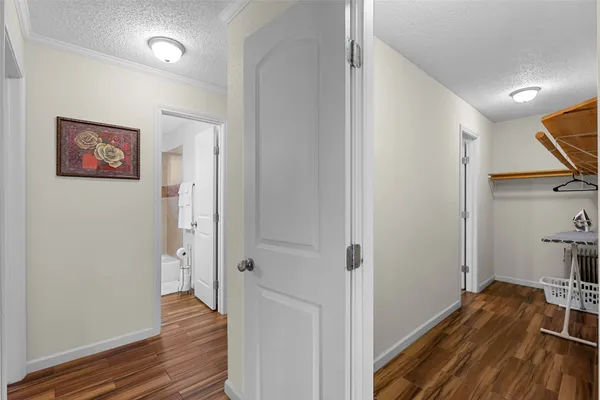 a view of a hallway with wooden floor and closet area
