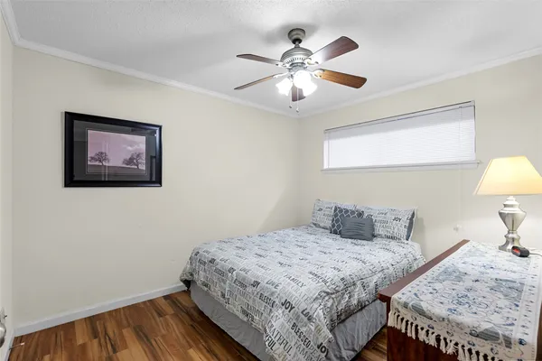 a bedroom with a bed and a lamp on dresser