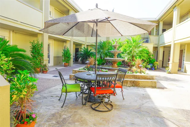a view of patio with chairs and table under an umbrella