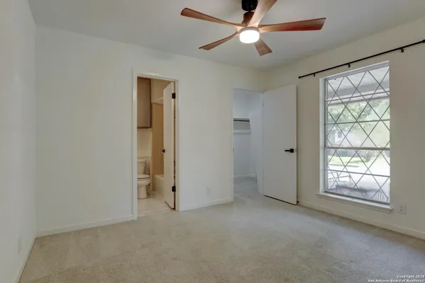 an empty room with chandelier fan