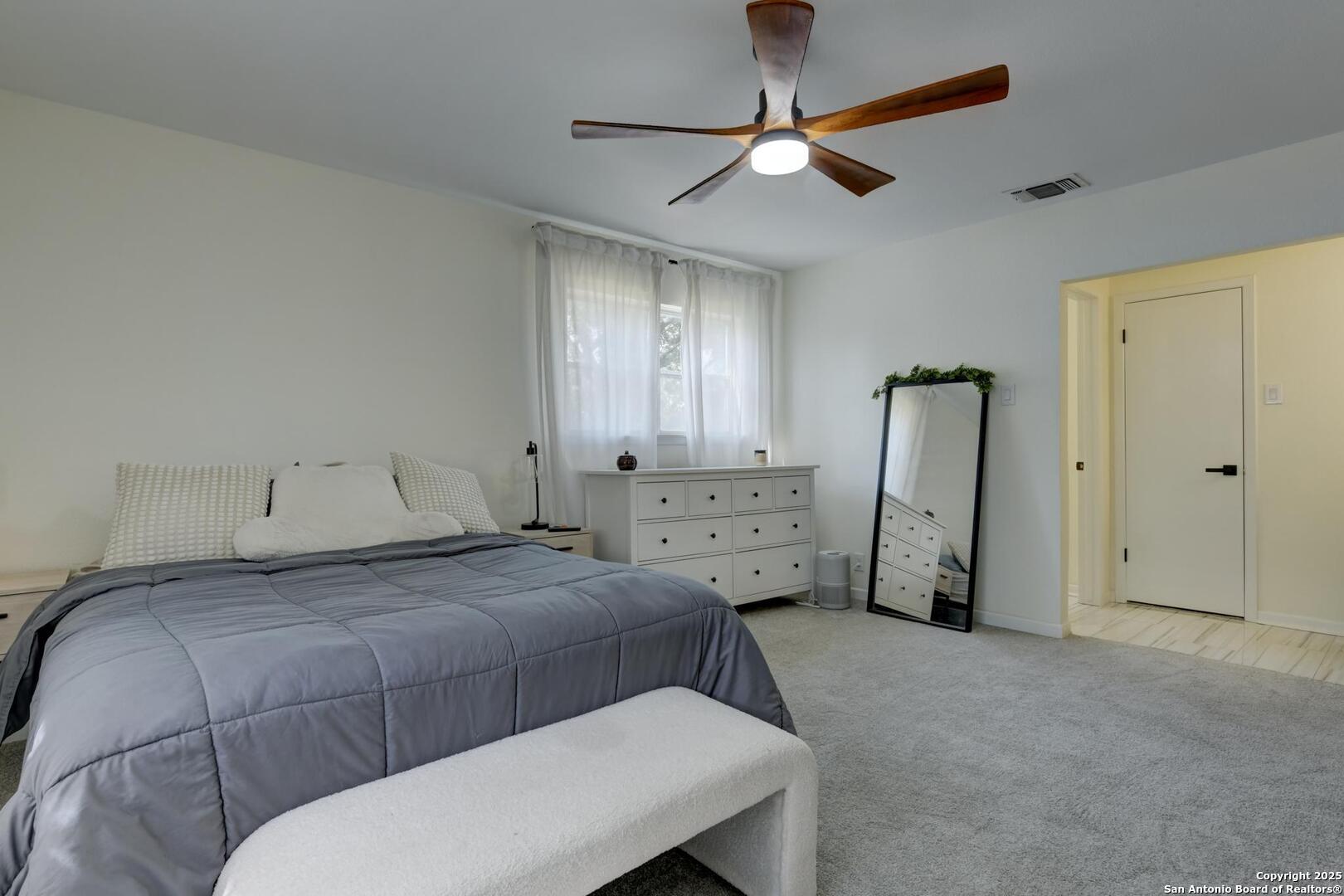 5018 Risada Street San Antonio, TX 78233 - Photo 25 of 39 a bedroom with a bed and a chandelier