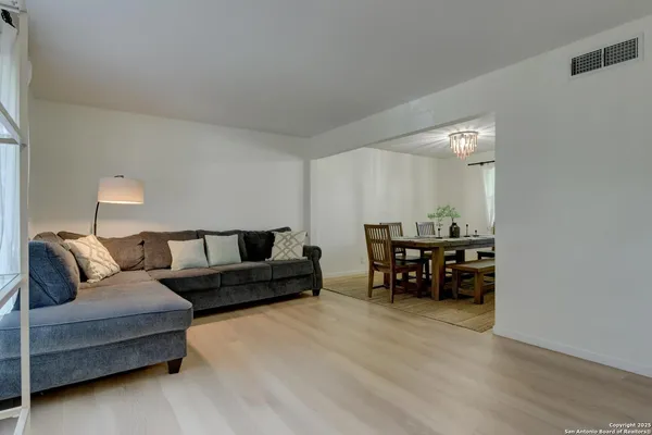 a living room with furniture and a dining table with kitchen view