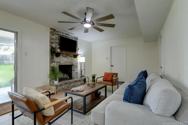 a living room with furniture a flat screen tv and a fireplace