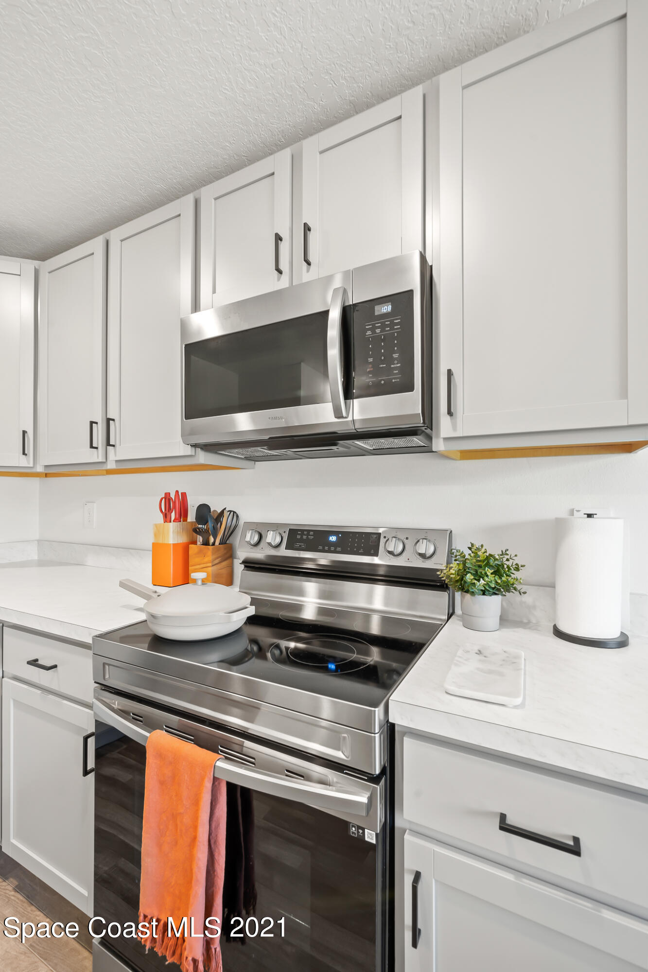 271 Wendover Road Southwest Palm Bay, FL 32908 - Photo 11 of 35 a kitchen with stainless steel appliances a stove a microwave a sink and cabinets