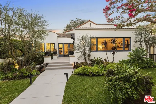 a front view of a house with a garden and plants