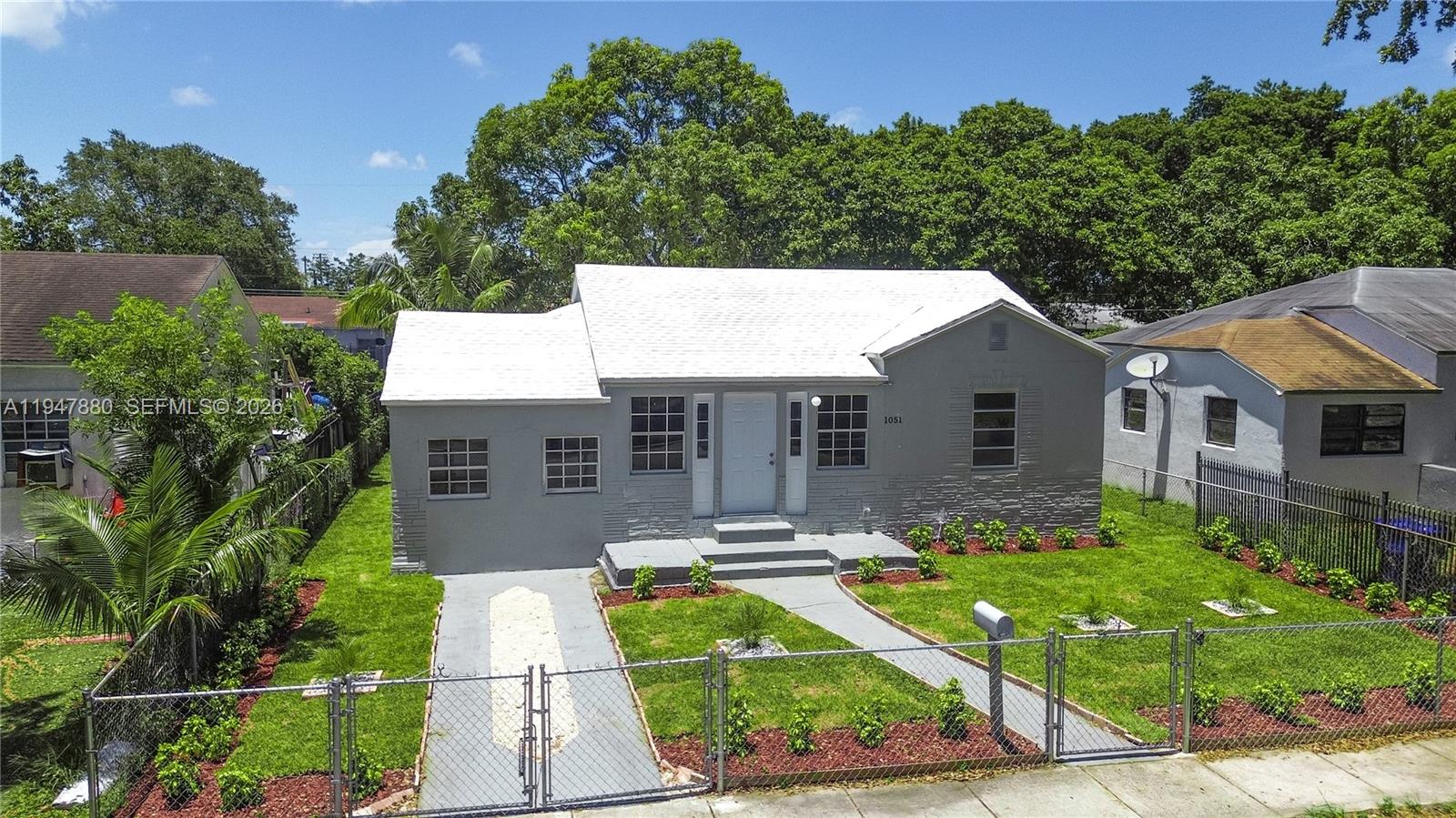 1051 Northwest 63rd Street Miami, FL 33150 - Photo 1 of 30 a front view of a house with garden