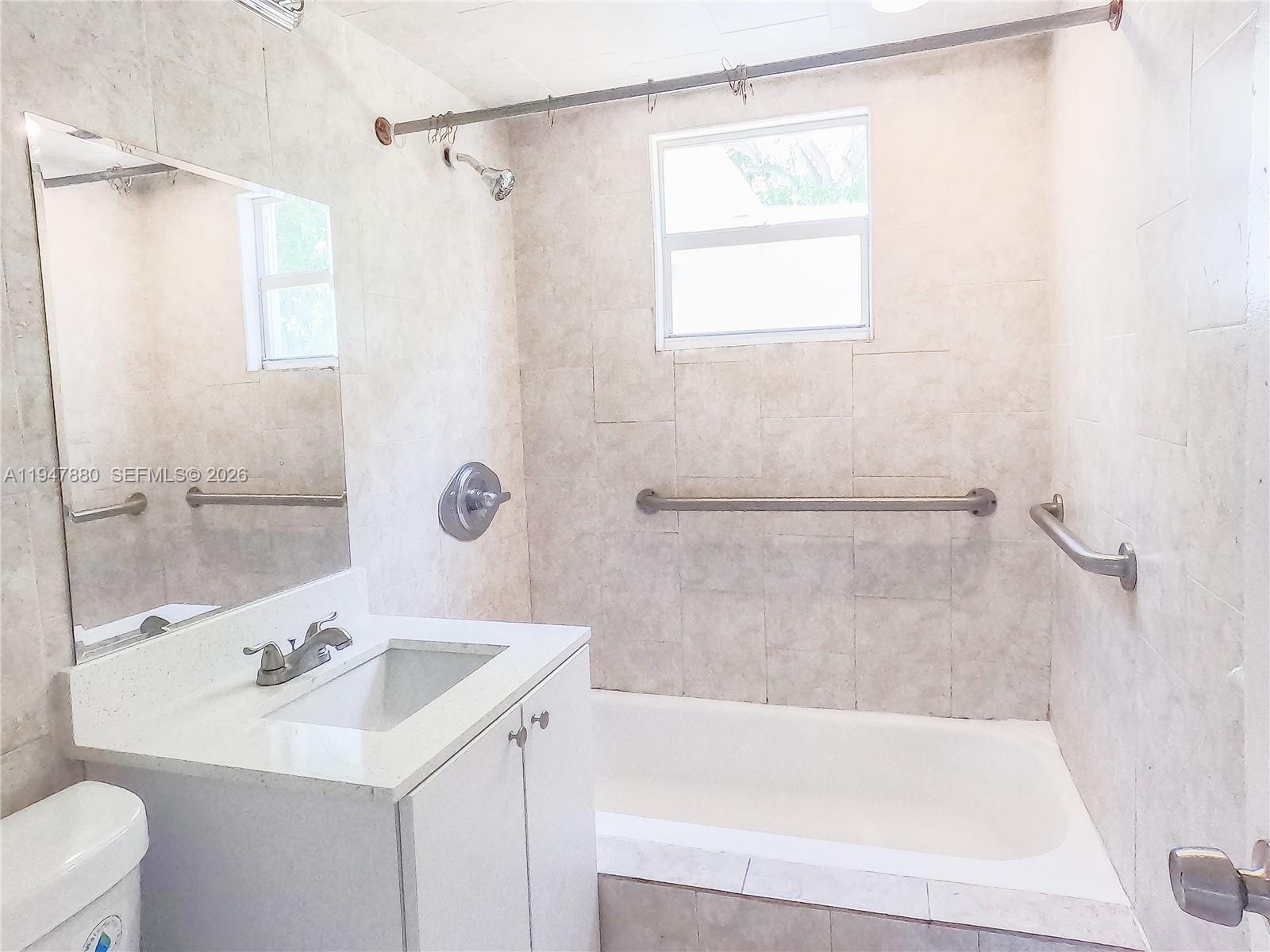 1051 Northwest 63rd Street Miami, FL 33150 - Photo 14 of 30 a bathroom with a sink a mirror and a bathtub