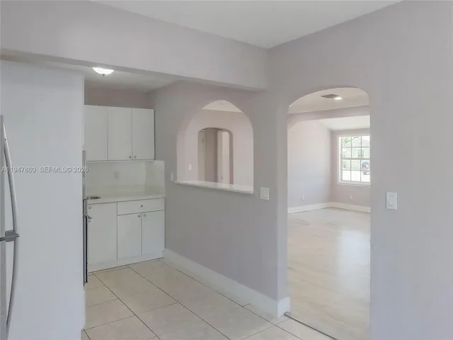a kitchen with white cabinets and refrigerator