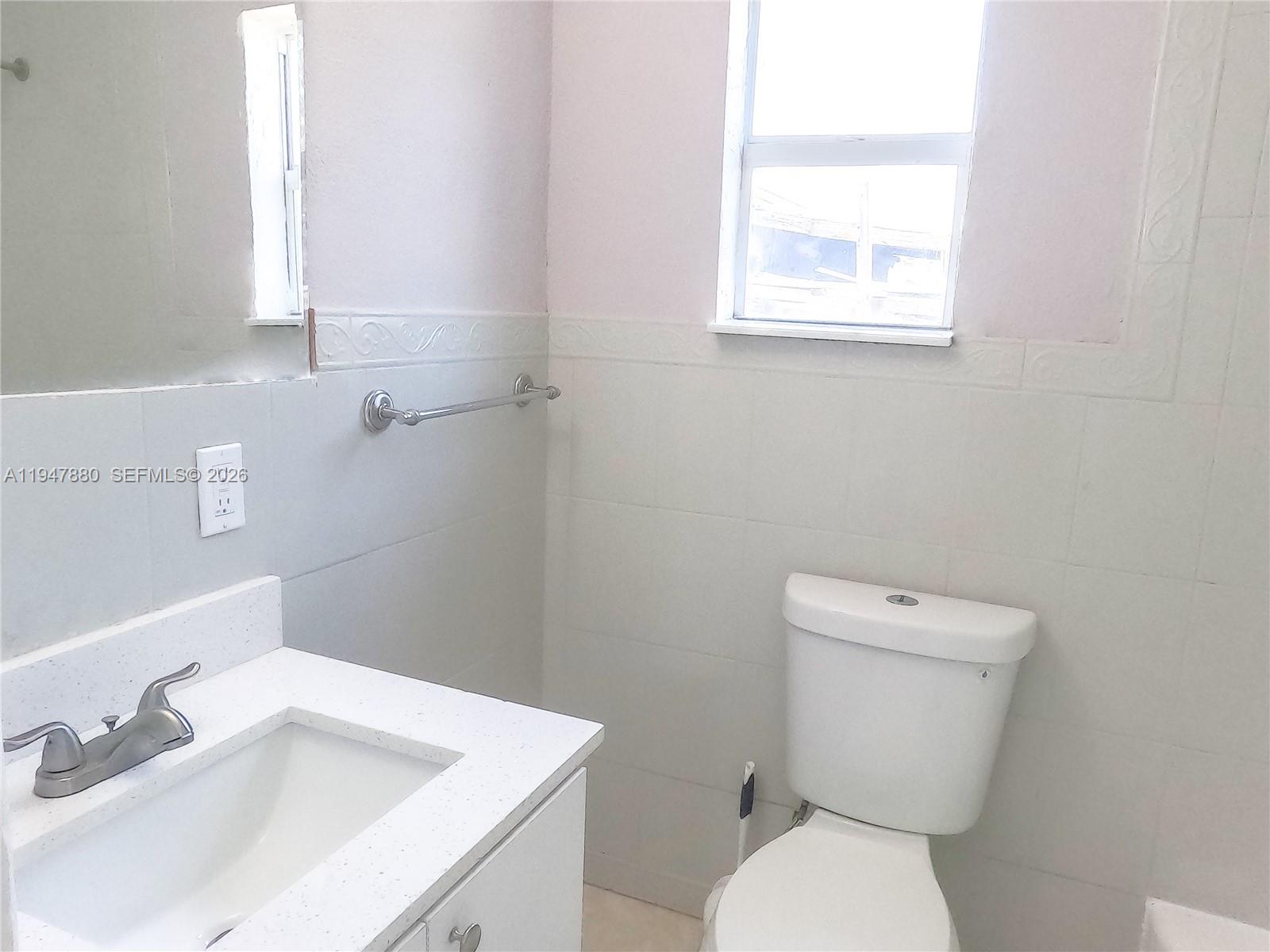 1051 Northwest 63rd Street Miami, FL 33150 - Photo 20 of 30 a white toilet sitting next to a bathroom sink