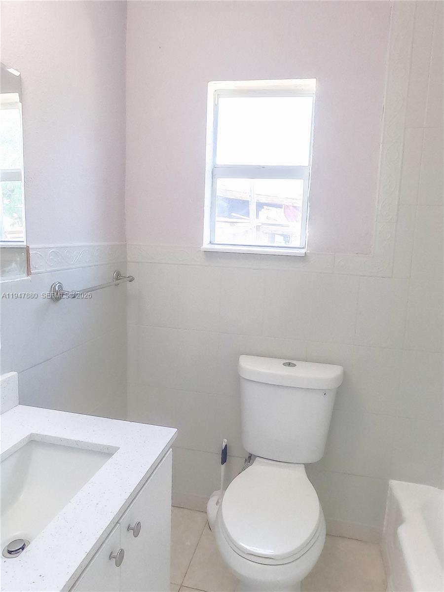 1051 Northwest 63rd Street Miami, FL 33150 - Photo 21 of 30 a white toilet sitting next to a bathroom sink