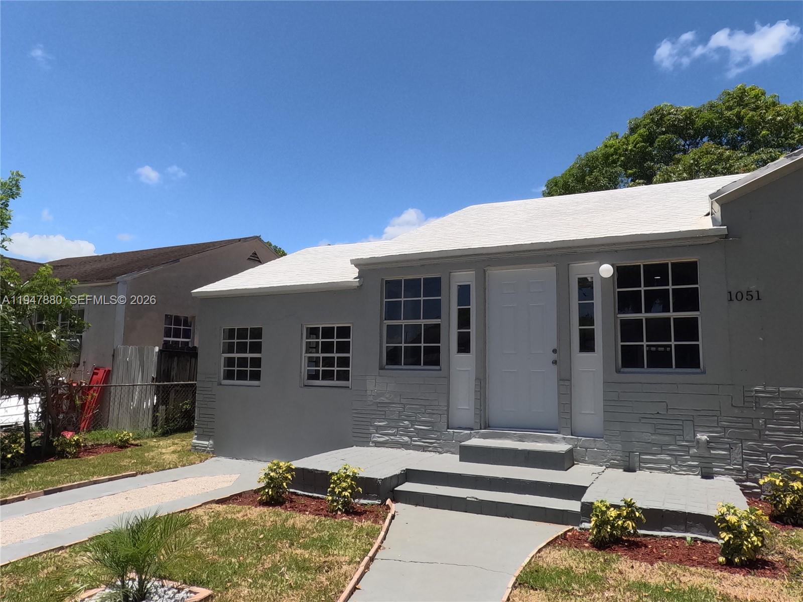 1051 Northwest 63rd Street Miami, FL 33150 - Photo 24 of 30 a front view of a house with porch