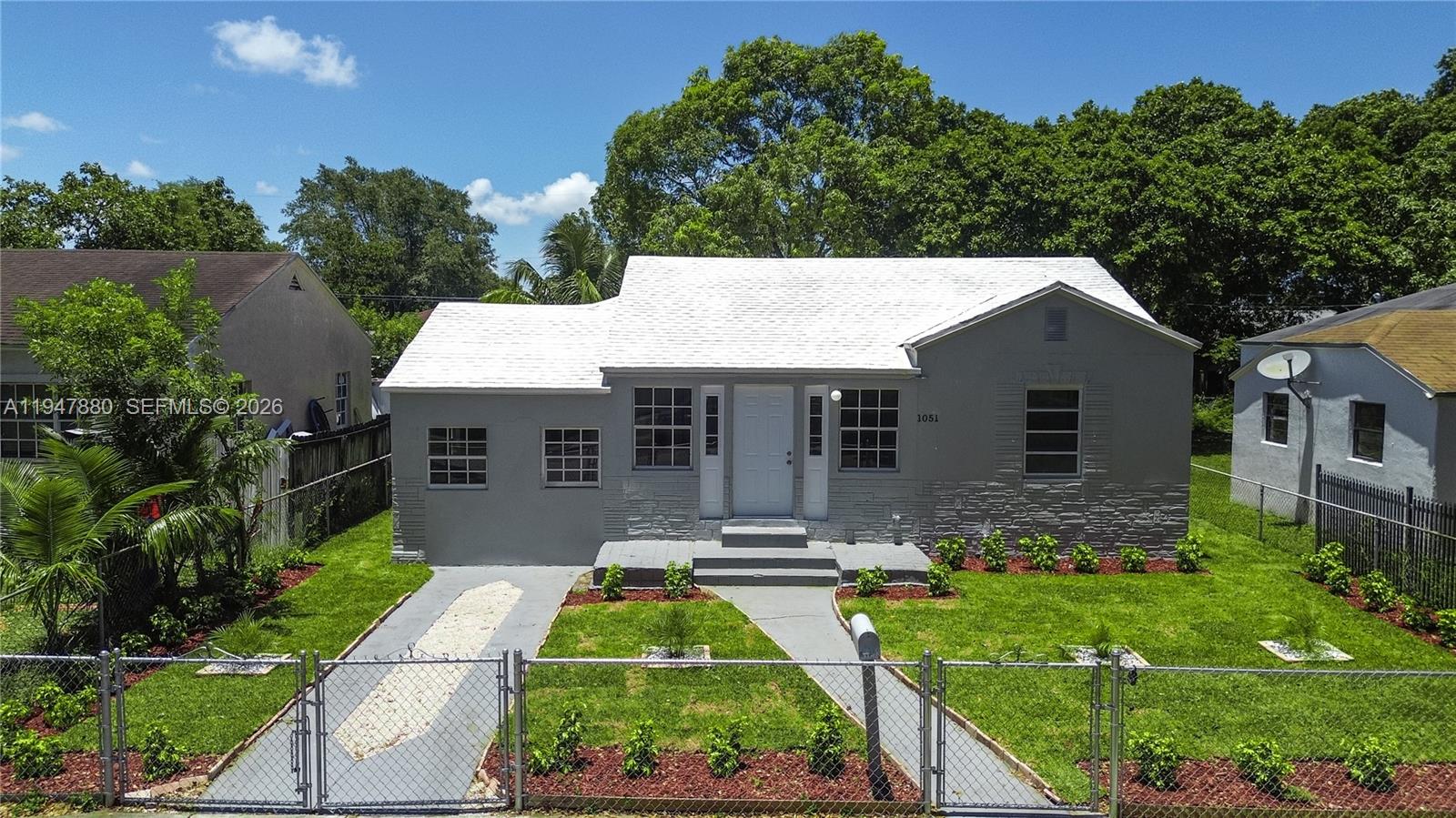 1051 Northwest 63rd Street Miami, FL 33150 - Photo 4 of 30 a front view of house with yard and green space