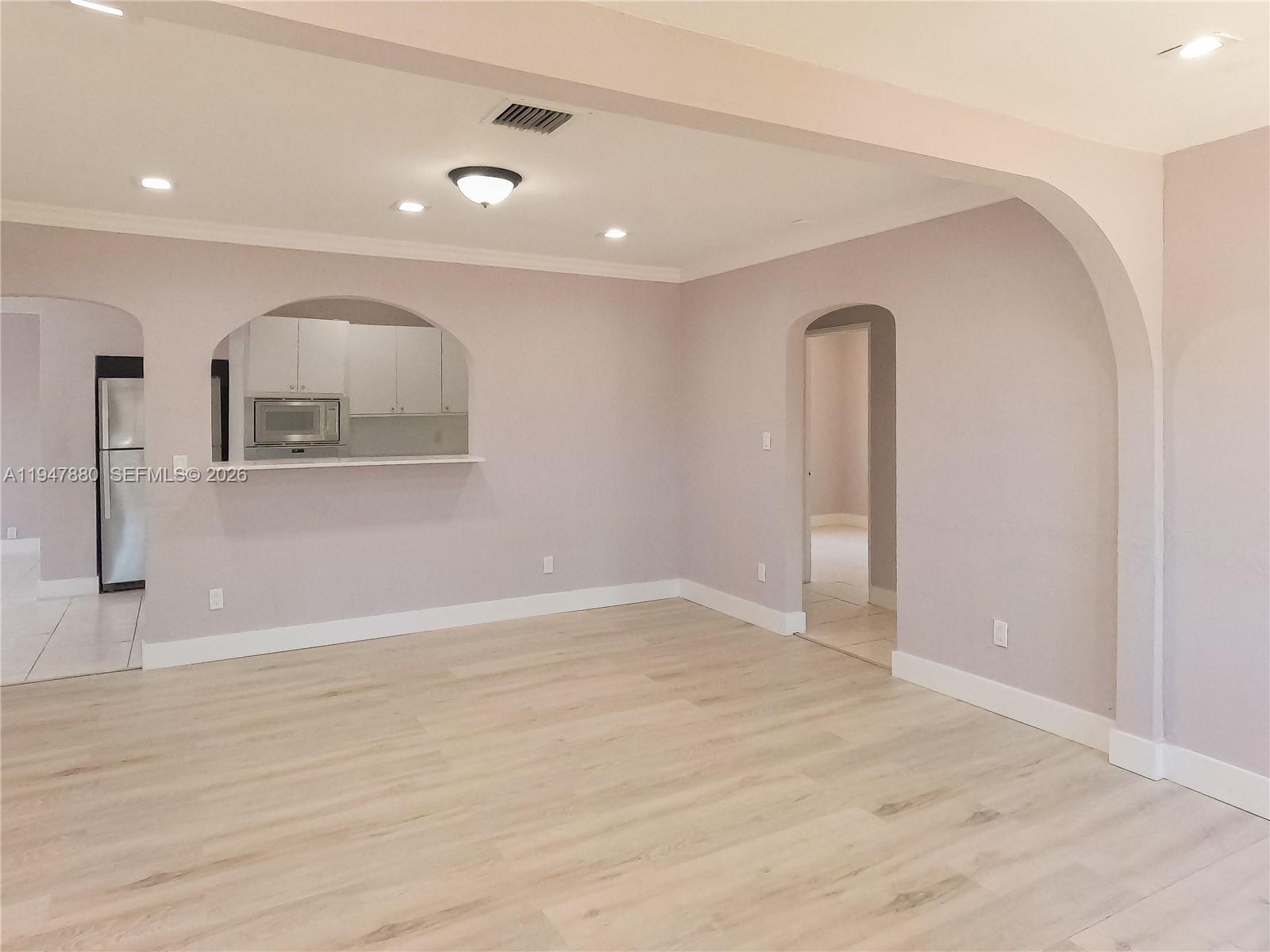 1051 Northwest 63rd Street Miami, FL 33150 - Photo 6 of 30 a view of an empty room with wooden floor and a window