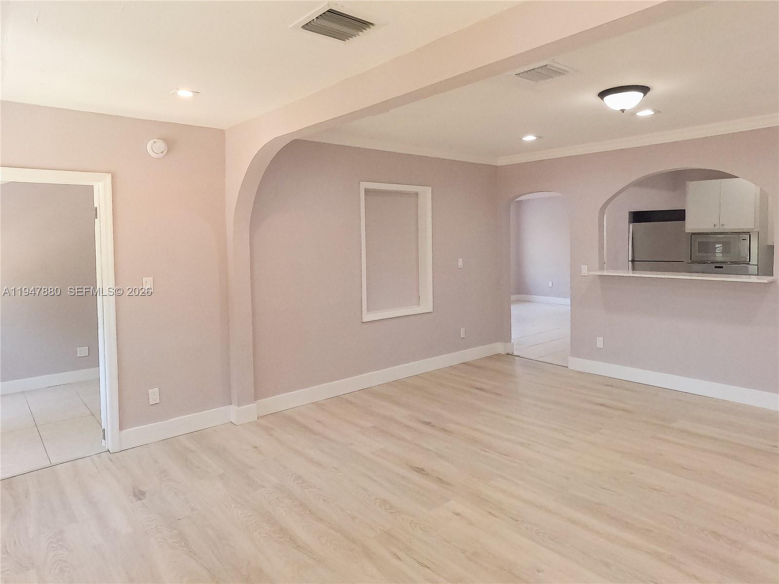 1051 Northwest 63rd Street Miami, FL 33150 - Photo 7 of 30 wooden floor in an empty room with a window