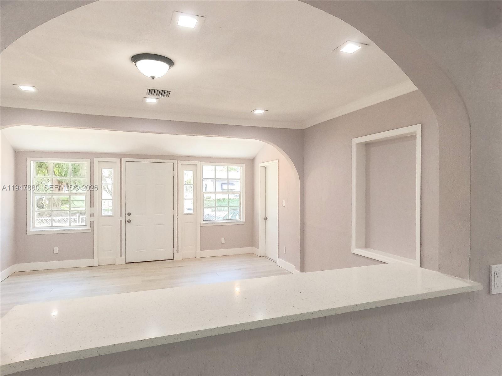 1051 Northwest 63rd Street Miami, FL 33150 - Photo 8 of 30 an empty room with windows and entrance