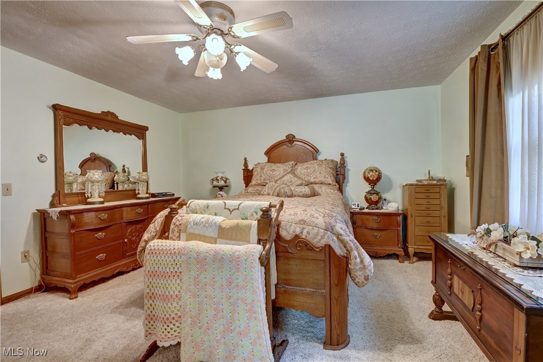 14965 Seacrist Road Salem, OH 44460 - Photo 12 of 43 Bedroom with a ceiling fan, light carpet, and a textured ceiling