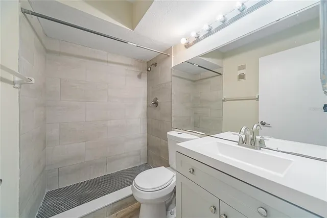 a bathroom with a sink a toilet and shower