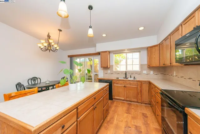 a kitchen with a sink a counter top space appliances and cabinets
