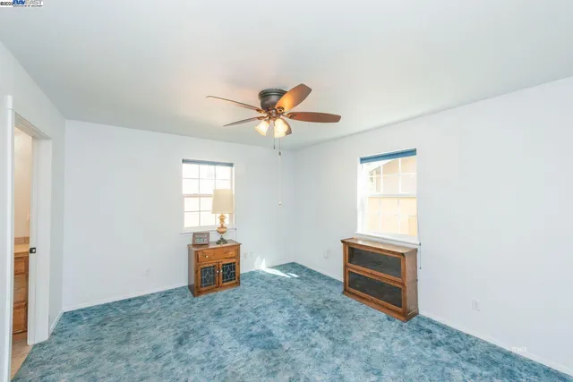 a view of a livingroom with a ceiling fan and carpet
