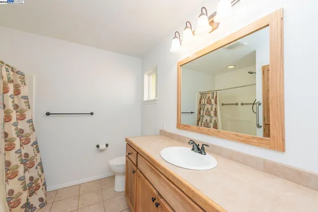 a room with chandelier fan and windows