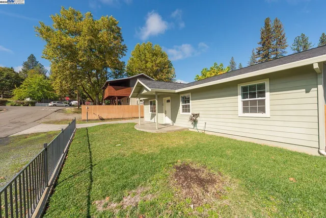 a front view of a house with a yard and trees