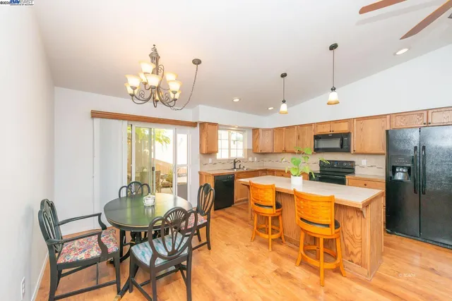 a view of a dining room with furniture a kitchen and chandelier