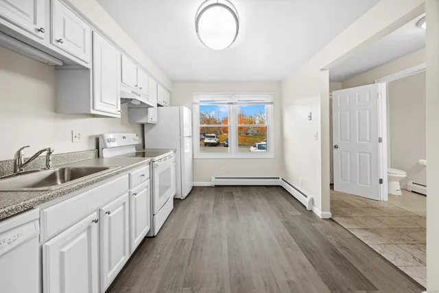 a kitchen with granite countertop a sink stove and cabinets