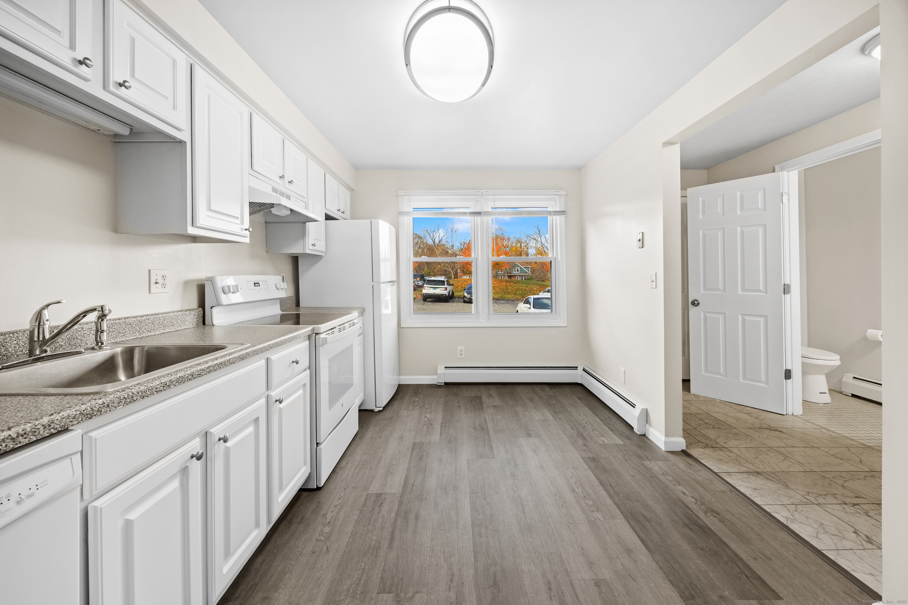 a kitchen with granite countertop a sink stove and cabinets