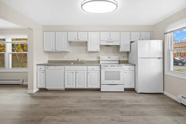 a kitchen with white cabinets and white appliances