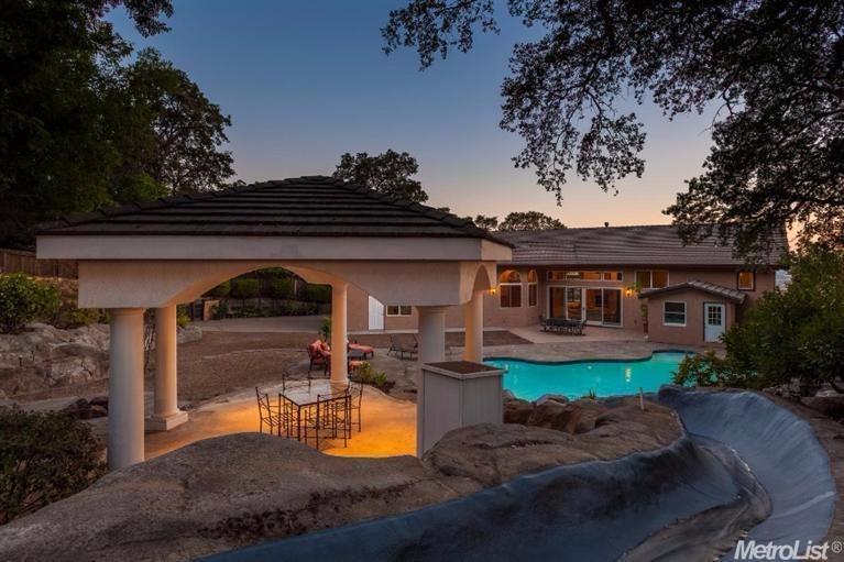 Beautiful Backyard Oasis with Water Slide, Gazebo, Firepit, Pool House with 1/2 bath, and lots of area for Entertaining!