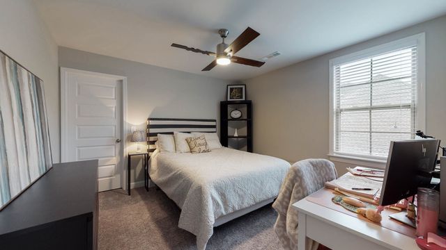 a living room with furniture and a flat screen tv next to a large window