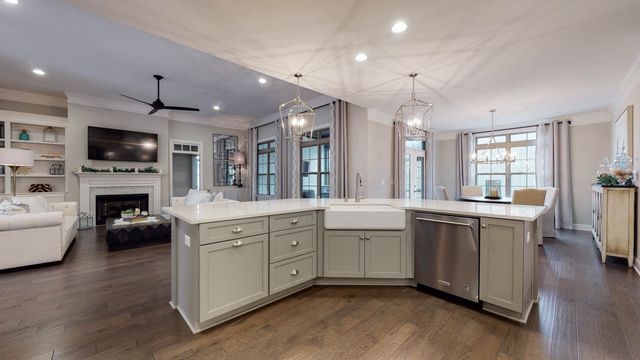 a kitchen with stainless steel appliances a stove a sink a microwave a refrigerator and white cabinets