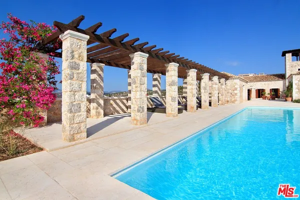 a view of a backyard with chair and table in the patio