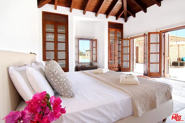 a bedroom with two beds and a large window