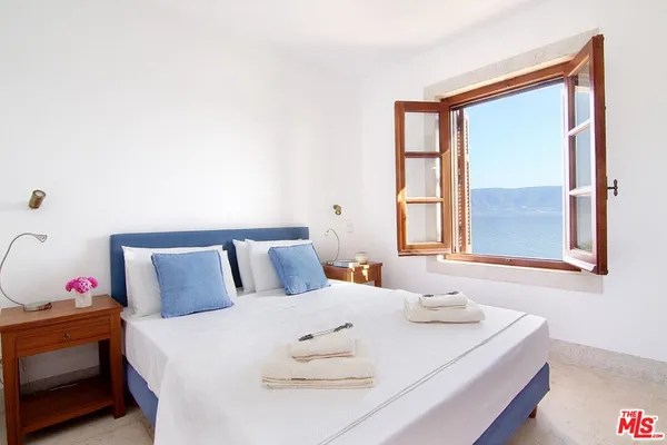 a bedroom with a large bed and a large window