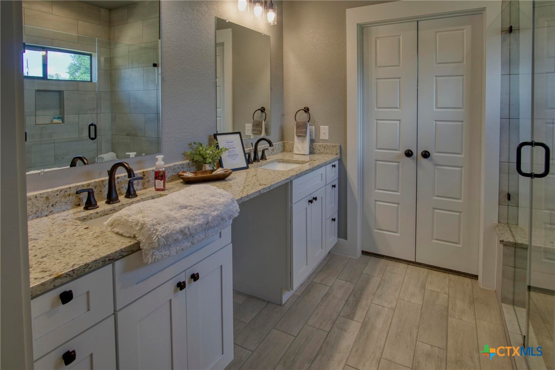 1112 Greenhill Drive Canyon Lake, TX 78133 - Photo 11 of 19 a bathroom with a granite countertop sink mirror and