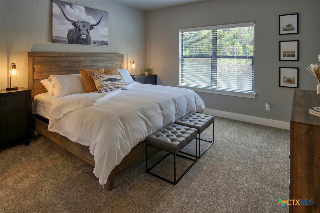 1112 Greenhill Drive Canyon Lake, TX 78133 - Photo 8 of 19 a bedroom with a bed a table and chair