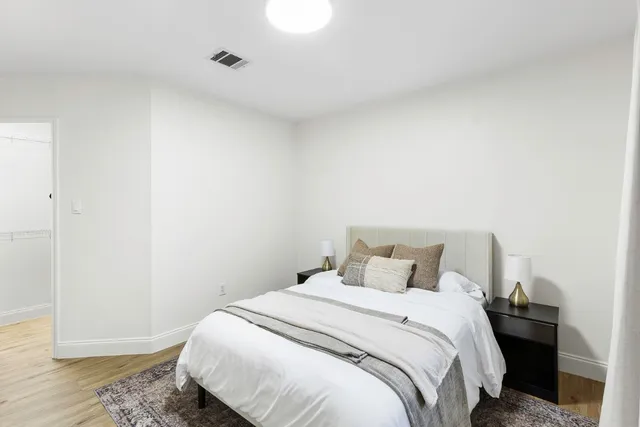 a bedroom with a bed and wooden floor