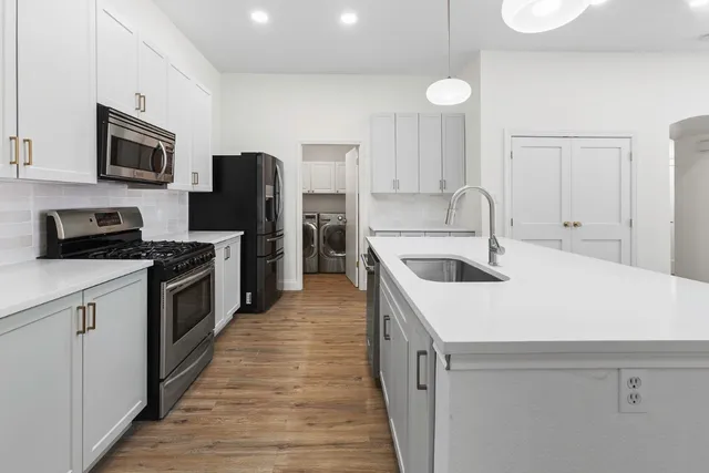 a kitchen that has a sink and a stove top oven