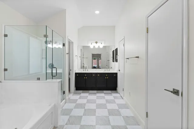 a bathroom with a bathtub shower sink and mirror