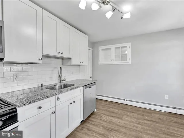 a kitchen with granite countertop cabinets stainless steel appliances a sink and dishwasher