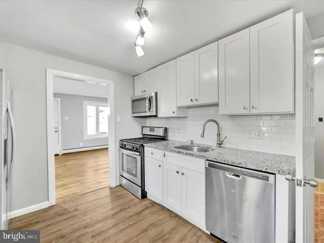 a kitchen with stainless steel appliances granite countertop a stove sink and cabinets