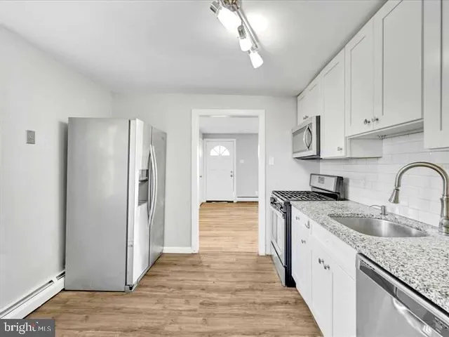 a kitchen with stainless steel appliances granite countertop a refrigerator and a stove
