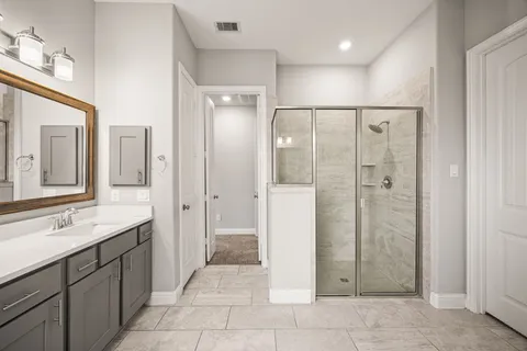 a bathroom with a mirror a double vanity sink and a shower